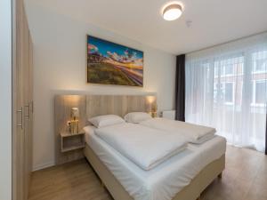 a bedroom with a large white bed in front of a window at Apartment in Zoutelande near the Beach in Zoutelande