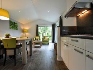 een keuken met een tafel en een eetkamer bij Nice chalet with dishwasher and wooded location in Vorden