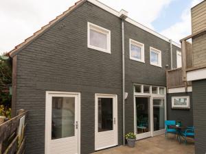 スコールルにあるApartment in Schoorl near Dunesの白いドアとパティオのある黒い家