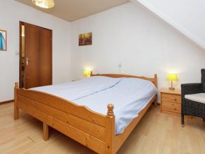 ein Schlafzimmer mit einem großen Bett und einem Stuhl in der Unterkunft Authentic holiday home in North Friesland in Holwerd