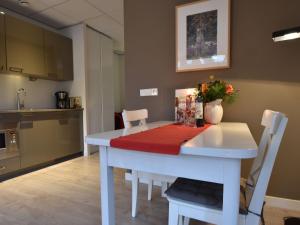 een keuken met een witte tafel met een rode doek erop bij Attractive apartments within walking distance of Bergen s town centre in Bergen