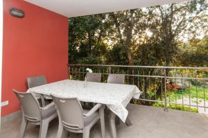 a white table and chairs on a balcony with a tree at SeaHouse 114 in Mali Lošinj