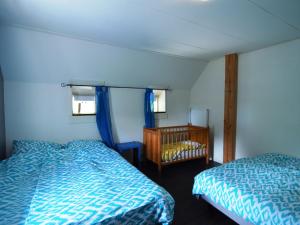 ein Schlafzimmer mit 2 Betten und einem Kinderbett in der Unterkunft Beautiful farmhouse in Wapse with fenced garden in Wapse