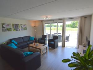 a living room with a couch and chairs and a table at Pretty Farmhouse in Haaksbergen near Forest in Haaksbergen