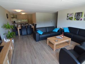 Sala de estar con sofás azules y mesa de centro en Pretty Farmhouse in Haaksbergen near Forest, en Haaksbergen