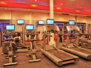 a gym with rows of tread machines and monitors at Cozy accommodation with a bathtub, located in Friesland in Franeker