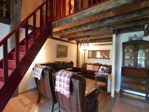 a living room with a staircase with chairs and a couch at Farmhouse in Nieuwleusen near Lake and Nature in Bergen op Zoom