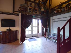 a living room with a television and a sliding glass door at Farmhouse in Nieuwleusen near Lake and Nature in Bergen op Zoom