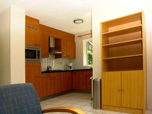 een keuken met houten kasten en een deur open bij Holiday home Vakantiepark Het Timmerholt 5 in Westerbork