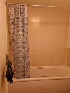 a bathroom with a tub and a shower curtain at Patton Place, Warrington, 1 Bedroom, Safari Themed, High Speed WiFi, Smart TV, Amazing Train Links, Secure Location, Hotel Vibe in a Home in Great Sankey