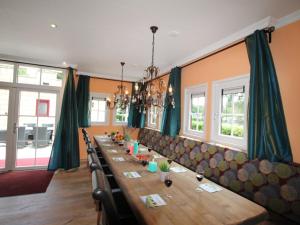 Un comedor largo con una mesa larga y sillas. en Villa in De Bult with modern comforts, en De Bult