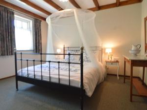 - une chambre avec un lit à baldaquin dans l'établissement Holiday home near the Drents Friese Wold, à Nijeberkoop