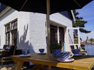 ヒンデローペンにあるLovely holiday home in Hindeloopenの木製テーブル(青白のカップ、傘付)