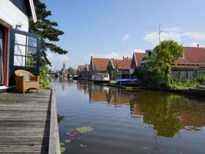 ヒンデローペンにあるLovely holiday home in Hindeloopenの家屋や船が並ぶ運河の景色を望めます。