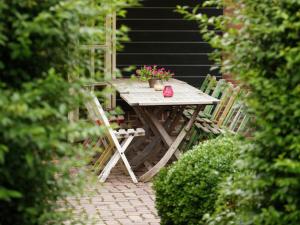 a wooden table with chairs and flowers on a patio at Beautiful Holiday Home in Lage Mierde with Fireplace in Lage Mierde