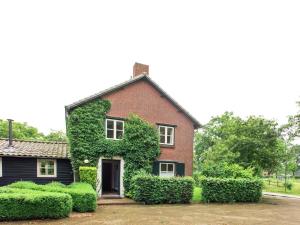 a red brick house with green ivy on it at Beautiful Holiday Home in Lage Mierde with Fireplace in Lage Mierde