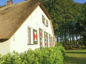 uma casa branca com telhado de palha em Peaceful Farmhouse in Doorn near Forest em Doorn