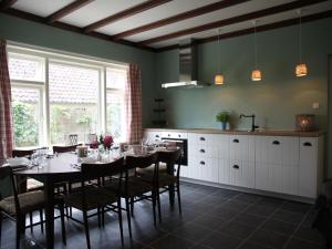 una sala da pranzo con tavolo e una cucina di Peaceful Farmhouse in Doorn near Forest a Doorn