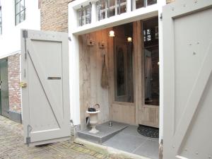 an open door of a building with a toilet outside at Boutique Holiday Home in Middelburg with Roof Terrace in Middelburg