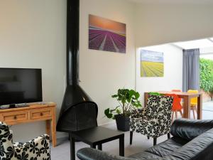 sala de estar con chimenea, sofá y sillas en Fresh and colorful holiday home near the beach sea dunes and lake, en Noordwijkerhout