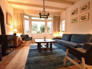 ベルゲンにあるComfortable Holiday Home in Bergen near Forestのリビングルーム(青いソファ、テーブル付)