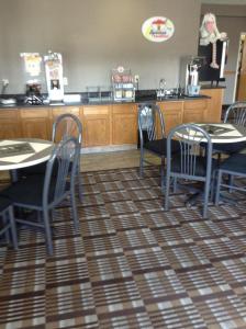 a restaurant with tables and chairs and a counter at Super 8 by Wyndham Carroll/East in Carroll