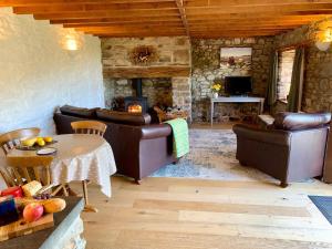 a living room with leather furniture and a fireplace at Stable Cottage in Newport
