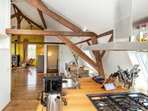 cocina con suelo y vigas de madera en Vibrant Farmhouse near Forest in Heeze-Leende, en Leende