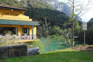a building next to a body of water next to a mountain at Hotel Casa Julián in Peñamellera Alta +31 photos