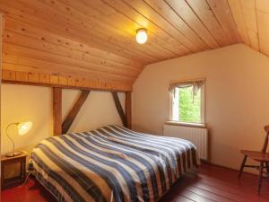 エンスヘーデにあるQuaint Farmhouse in Enschede with Terraceの木製の天井の客室で、ベッドルーム1室(ベッド1台付)
