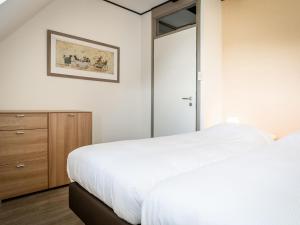 デ・カクスドルプにあるSeals Cozy Farm Stayのベッドルーム1室(白いベッド1台、ガラスのスライドドア付)