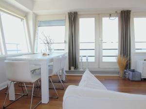 a white table and chairs in a room with windows at Heritage Holiday Home in Huisduinen near Sea in Huisduinen