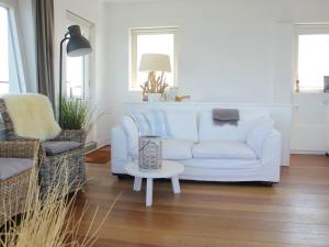 a living room with a white couch and a table at Heritage Holiday Home in Huisduinen near Sea in Huisduinen