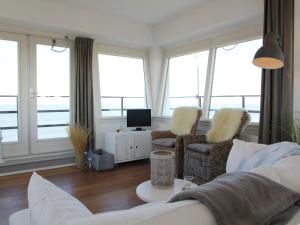 a living room with a couch and chairs and windows at Heritage Holiday Home in Huisduinen near Sea in Huisduinen