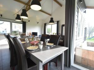 comedor con mesa blanca y sillas en Lovely cottage in the middle of nature en Keyenborg