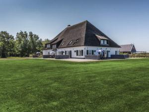 デ・カクスドルプにあるFarmhouse in Texel near De Slufter Reserveの緑地黒屋根白屋