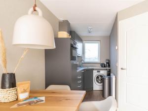 a kitchen with a table and a kitchen with a washing machine at Sunny Bungalow in Heart of Texel in De Cocksdorp