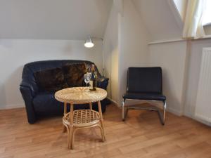 ベルゲン・アーン・ゼーにあるComfortable apartment with sea viewのリビングルーム(ソファ、テーブル、椅子付)