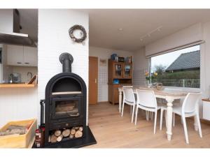 a fireplace in a kitchen with a table and chairs at Quiet location yet close to the beach and center large enclosed garden in Renesse