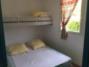 een slaapkamer met een stapelbed en een raam bij Chalet La Dragonniere in Vias