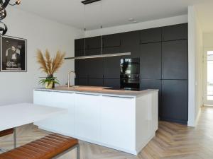 a kitchen with a white counter and black cabinets at Luxury villa on the waterfront with jetty in Zeewolde