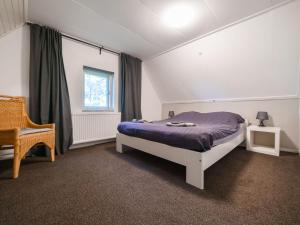 ein Schlafzimmer mit einem Bett, einem Stuhl und einem Fenster in der Unterkunft Farmhouse in Dalfsen near Forest Trails in Dalfsen