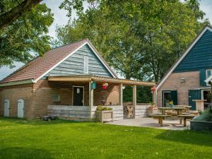 ein Haus mit Terrasse und Picknicktisch in der Unterkunft Farmhouse in Dalfsen near Forest Trails in Dalfsen