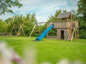 einen Spielplatz mit Rutsche und Spielstruktur in der Unterkunft Farmhouse in Dalfsen near Forest Trails in Dalfsen