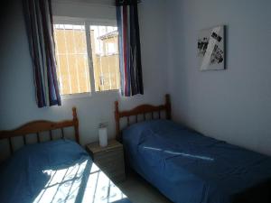 ein Schlafzimmer mit zwei Einzelbetten und einem Fenster in der Unterkunft Casa Joleen 2 in Villamartin + 37 Fotos