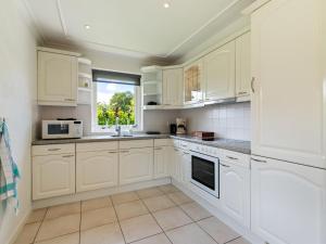 a white kitchen with white cabinets and a window at Quaint Holiday Home in Putten with Garden in Putten