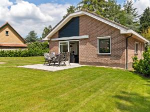 a house with a table and chairs in a yard at Quaint Holiday Home in Putten with Garden in Putten