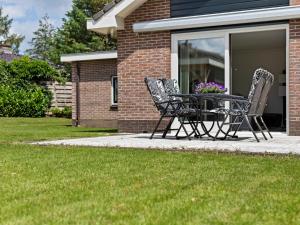 a table and chairs sitting outside of a house at Quaint Holiday Home in Putten with Garden in Putten
