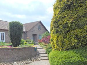 a house with a garden between two large trees at Dreamy Holiday Home in Sweikhuizen in Spaubeek