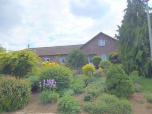 a house with a garden of flowers and bushes at Dreamy Holiday Home in Sweikhuizen in Spaubeek